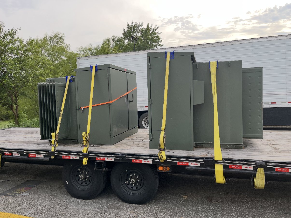 Pad-mounted and oil-filled transformers we purchased, strapped to our flatbed trailer for transport